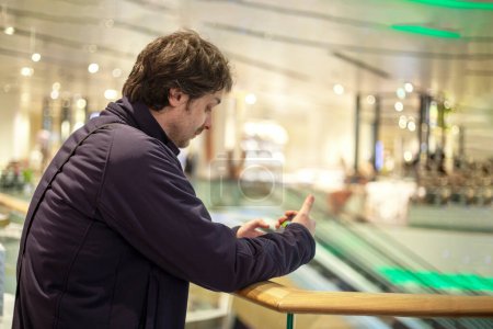 Photo for Happy young unshaven man looking in smartphone in mall, horizontal - Royalty Free Image