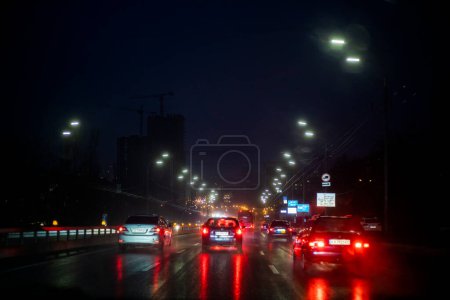 Nacht nasse Autobahn in der Stadt beleuchtet von Laternen. Schlechtes Wetter