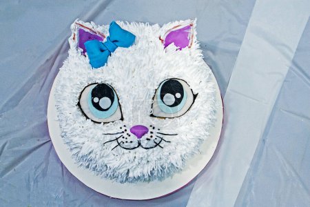 Téléchargez les photos : Beau gâteau de chat blanc avec des bougies à une fête d'anniversaire d'enfants vue de dessus. fête des enfants - en image libre de droit