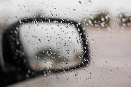 Téléchargez les photos : Gouttes de pluie sur le rétroviseur droit de la voiture, mauvaise visibilité. Mauvais temps - en image libre de droit