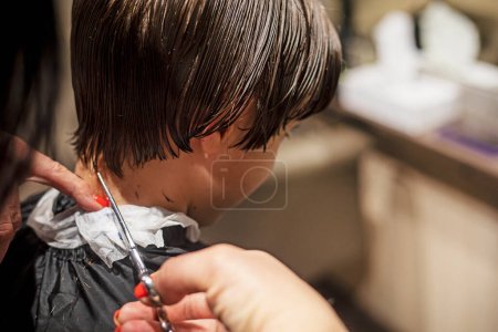 Téléchargez les photos : Salon de coiffure coupe les pointes de cheveux propres humides à l'arrière de la tête d'un adolescent avec des ciseaux - en image libre de droit
