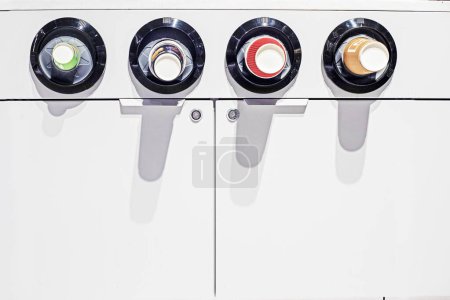 Foto de Vasos de papel en una máquina expendedora con varias bebidas - Imagen libre de derechos
