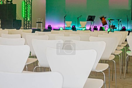 Téléchargez les photos : Salle de conférence vide avec chaises blanches avant le concert - en image libre de droit