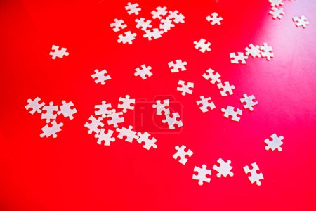 Photo for Scattered puzzles on a red background. Business Building Concept - Royalty Free Image