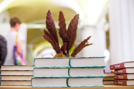 Téléchargez les photos : Livres et manuels sur une table en bois empilés sur un fond de plantes à l'intérieur. L'éducation. retour à l'école - en image libre de droit