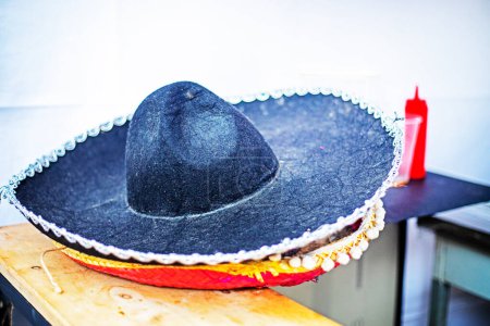 Foto de Sombrero mexicano negro de ala ancha en el mostrador cerca de la cerveza y los perros calientes. comida callejera - Imagen libre de derechos