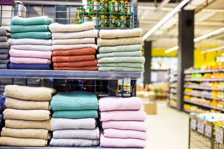 multi-colored towels in a stack on the shelves in the supermarket. family shopping