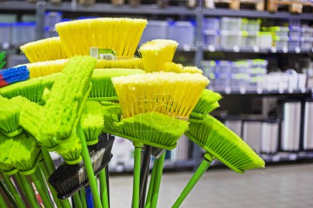 Photo for Yellow and green mops brooms for cleaning in the store - Royalty Free Image