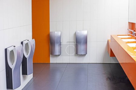 Photo for Toilet with washbasins, hand dryers in a supermarket in light orange colors - Royalty Free Image