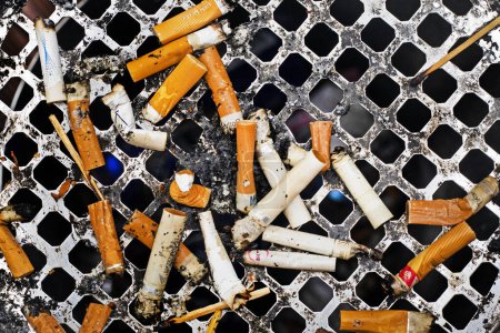 Foto de Primer plano de un montón de colillas de cigarrillos en un cenicero exterior. Flatlay. Los cigarrillos y fumar son perjudiciales para la salud - Imagen libre de derechos