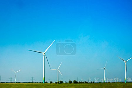 Foto de Molino de viento sobre un fondo de cielo azul en un campo. Energía ecológica. Crisis económica mundial - Imagen libre de derechos