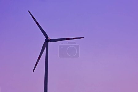 Foto de Silueta de un molino de viento al atardecer. Crisis económica - Imagen libre de derechos