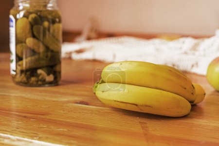 Téléchargez les photos : Bouquet de bananes avec un réservoir de concombres en conserve marinés - en image libre de droit