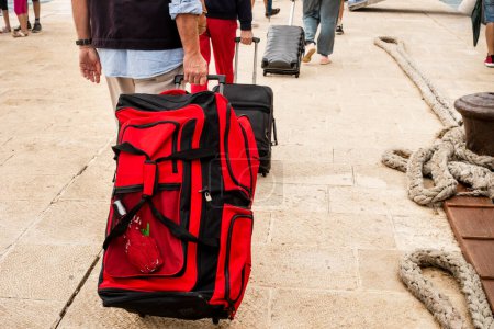 Téléchargez les photos : Les passagers transportent des valises le long de la jetée jusqu'au paquebot. Réfugiés, guerre à Izratl et en Ukraine - en image libre de droit