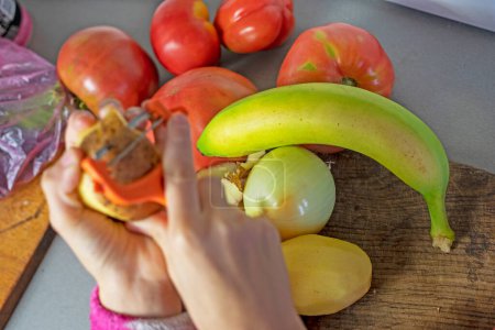Téléchargez les photos : Banane verte à côté des tomates sur le comptoir dans la cuisine - en image libre de droit