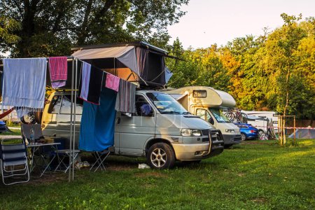 Photo for Parking motorhomes and tents at a campsite on a warm day. Traveling by car in Europe and America on vacation - Royalty Free Image