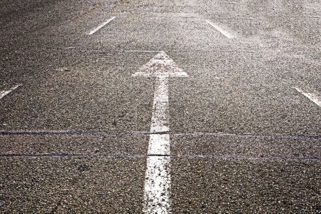 Téléchargez les photos : Pointeurs flèches blanches sur la route asphaltée - en image libre de droit