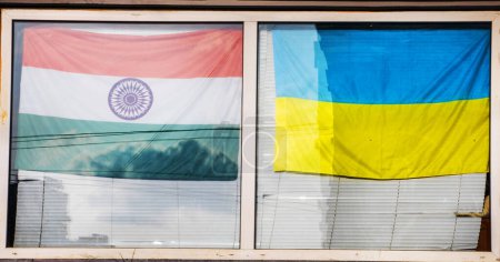 Téléchargez les photos : Drapeau ukrainien et drapeau indien côte à côte dans la fenêtre. Soutien et guerre en Ukraine - en image libre de droit