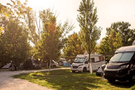 Foto de Vida de camping con autocaravanas y coches y tiendas de campaña por la mañana temprano. viajes y vacaciones en coche - Imagen libre de derechos