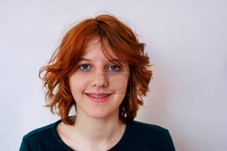 Téléchargez les photos : Portrait d'une adolescente élégante heureuse avec des cheveux rouges anime avec les yeux grands ouverts. Psychologie de l'âge - en image libre de droit