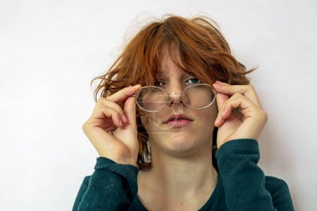 Téléchargez les photos : Portrait d'une adolescente aux cheveux roux portant des lunettes. Psychologie et complexes d'adolescents - en image libre de droit