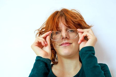 Foto de Retrato de una adolescente con el pelo rojo usando gafas. Psicología y complejos de adolescentes - Imagen libre de derechos
