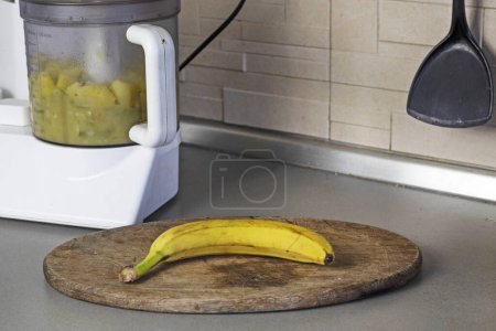 Foto de Machacar plátanos y manzanas en un procesador de alimentos en la cocina - Imagen libre de derechos