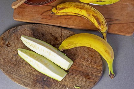 Téléchargez les photos : Bouquet de bananes avec des morceaux de courgettes sur le comptoir dans la cuisine - en image libre de droit