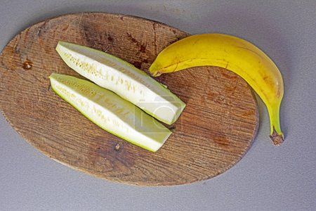 Téléchargez les photos : Bouquet de bananes avec des morceaux de courgettes sur le comptoir dans la cuisine - en image libre de droit