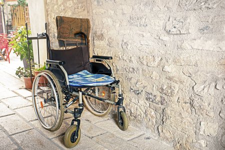 Foto de Silla de ruedas vacía para personas con movilidad reducida en la calle - Imagen libre de derechos