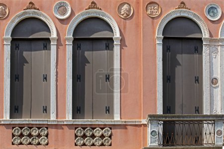Téléchargez les photos : Fenêtres architecturales vénitiennes semi-circulaires sur le mur rouge. voyage à venise - en image libre de droit