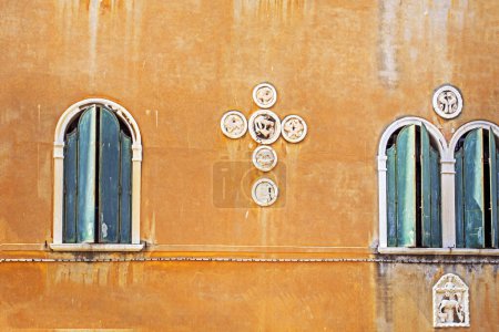Téléchargez les photos : Architecturale vénitienne fenêtres semi-circulaires sur un mur jaune. voyage à venise - en image libre de droit