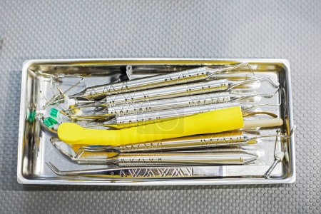 Téléchargez les photos : Instruments dentaires dans un récipient médical sur la table, vue de dessus - en image libre de droit