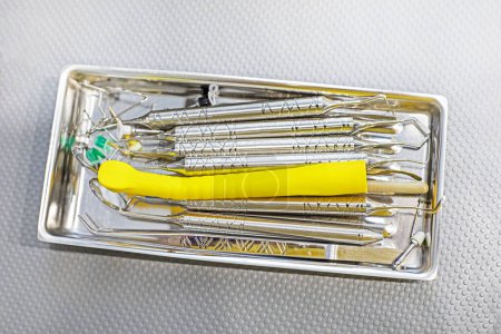 Téléchargez les photos : Instruments dentaires dans un récipient médical sur la table, vue de dessus - en image libre de droit