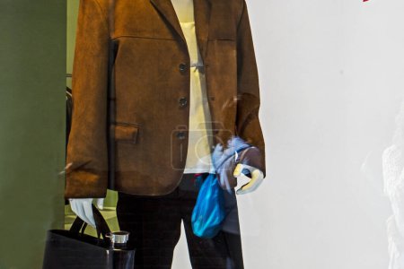 Foto de Elegante chaqueta de hombre marrón con un bolso de hombre en un escaparate de la tienda de ropa. Estilo y moda - Imagen libre de derechos