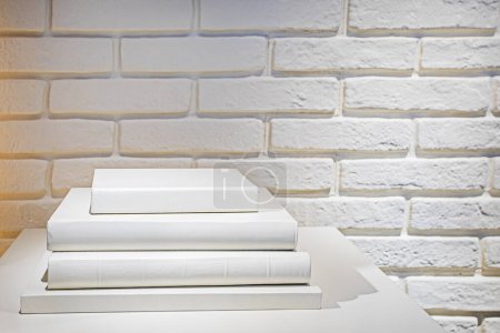Photo for Stack of white books on a white wall background. Education and - Royalty Free Image