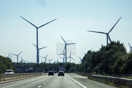 Photo for Wind power station along the highway during the day. Saving electricity - Royalty Free Image