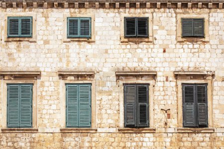 ancient windows with green shutters in an ancient Roman masonry building