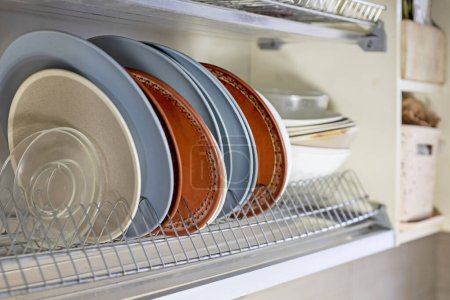 Téléchargez les photos : Différentes plaques de verre et de céramique pour stand alimentaire dans l'armoire de cuisine - en image libre de droit