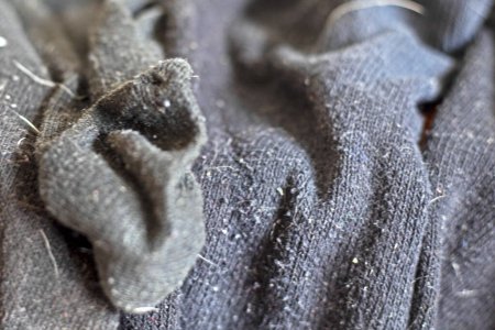 Hintergrund gewaschener schwarzer Männersocken in Wolle auf dem Kleiderschrank