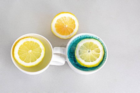 Foto de Dos tazas con rodajas de limón en la mesa y limón. Psicología salud y actitud - Imagen libre de derechos