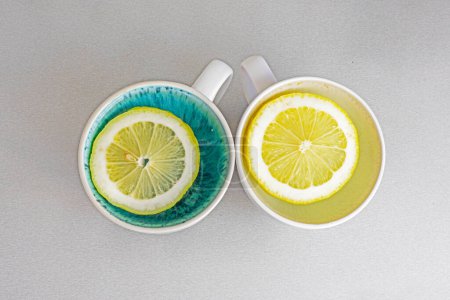 Foto de Dos tazas con rodajas de limón en la mesa. Psicología salud y actitud - Imagen libre de derechos