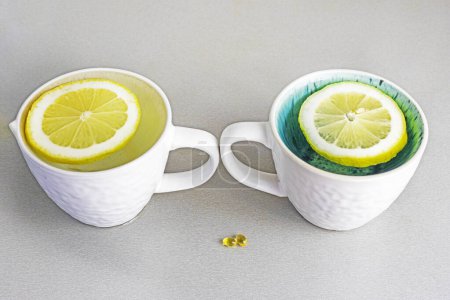 two cups with lemon slices on the table and vitamin D. Psychology health and attitude