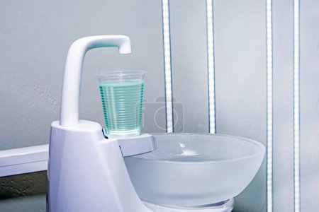 glass of liquid for rinsing teeth in a dental office. dental treatment and care