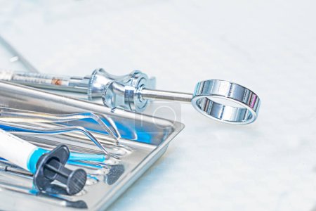 Téléchargez les photos : Instruments dentaires se trouvent dans un récipient sur la table. Soins dentaires et soins dentaires - en image libre de droit
