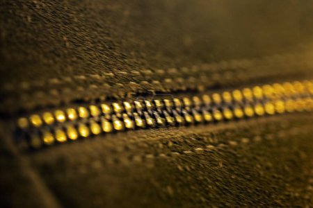 close-up of a zipper on a khaki leather product. Fashion and style in clothes and shoes