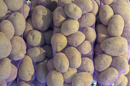 pre-packed varietal potatoes in nets in the supermarket