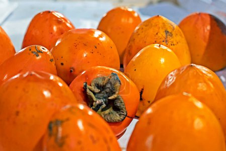 ripe orange Sharon persimmon in a container in a supermarket