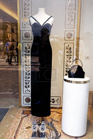 stylisches schwarzes langes Kleid mit schwarzer Handtasche auf einer Schaufensterpuppe