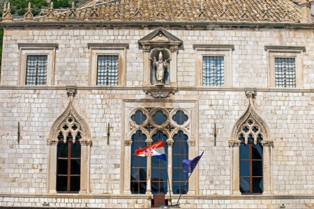 Banderas croatas y de la OTAN en un antiguo edificio con mampostería romana